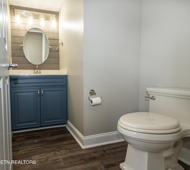 bathroom with hardwood / wood-style floors, vanity, and toilet