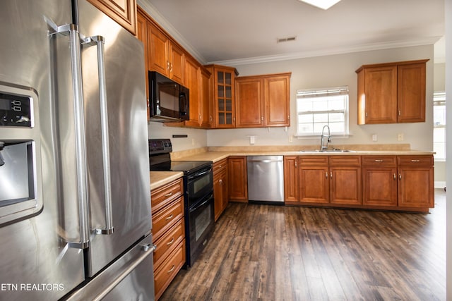 kitchen with sink, dark hardwood / wood-style floors, ornamental molding, and black appliances