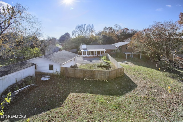 back of house with a lawn and a patio