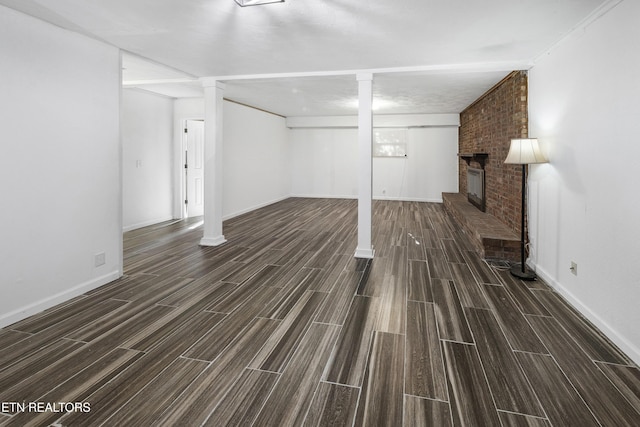 basement with dark hardwood / wood-style floors and a brick fireplace