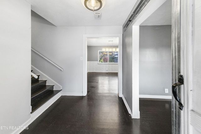 entryway featuring a barn door and dark wood-type flooring