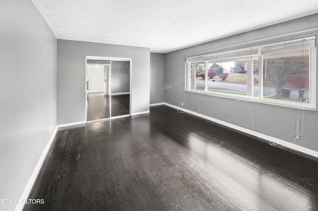 unfurnished room with dark hardwood / wood-style floors