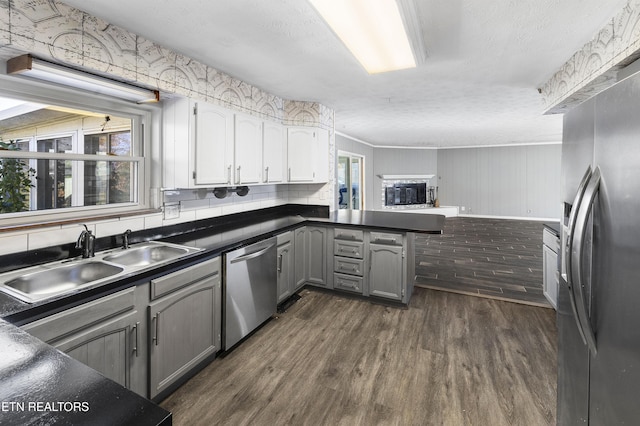 kitchen with ornamental molding, gray cabinetry, stainless steel appliances, sink, and dark hardwood / wood-style floors