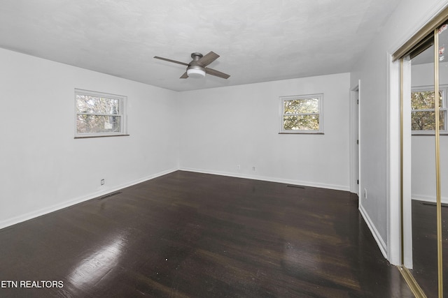 spare room with dark hardwood / wood-style floors and ceiling fan