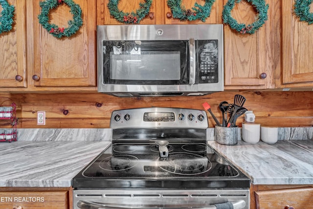 kitchen with light stone countertops and appliances with stainless steel finishes