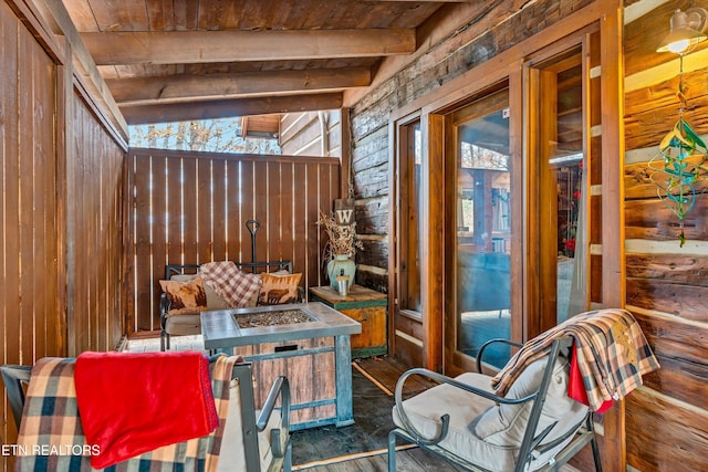 interior space featuring vaulted ceiling with beams, wooden ceiling, and wood walls