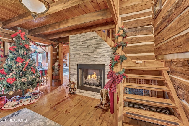 interior space featuring hardwood / wood-style floors, a large fireplace, wooden ceiling, and beam ceiling