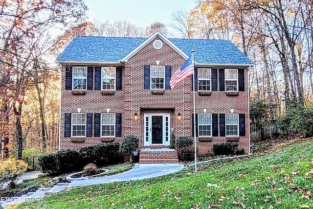 colonial home with a front lawn