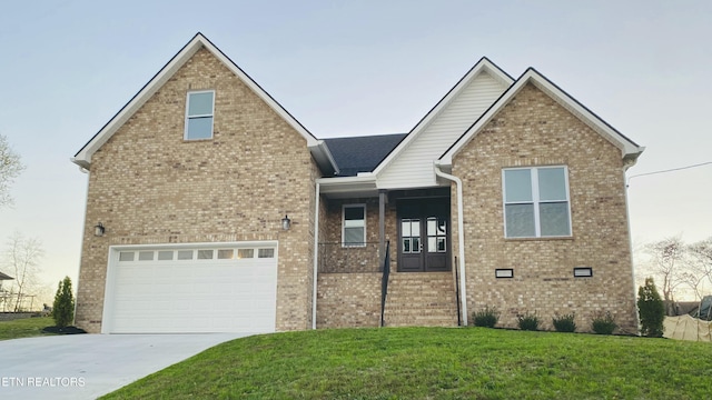 view of front of house featuring a garage, a front yard, brick siding, and driveway