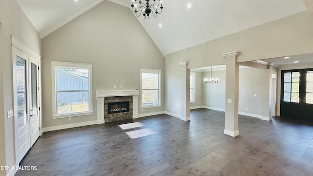 unfurnished living room featuring dark wood finished floors, high vaulted ceiling, a glass covered fireplace, a chandelier, and baseboards