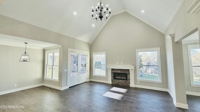 unfurnished living room with dark wood-style floors, a fireplace, baseboards, and a wealth of natural light