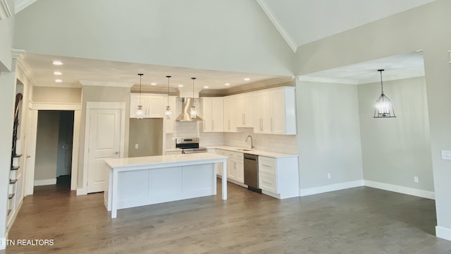 kitchen with stainless steel appliances, a sink, white cabinetry, backsplash, and wall chimney exhaust hood