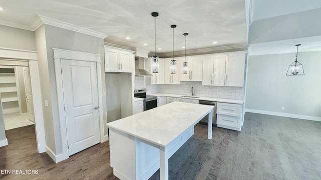 kitchen with stainless steel appliances, a kitchen island, a sink, ornamental molding, and dark wood finished floors