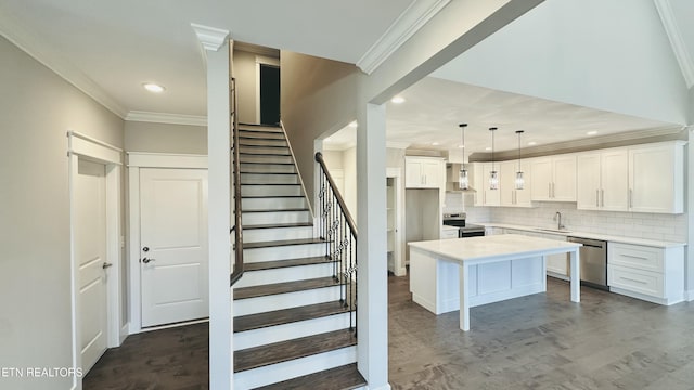 kitchen featuring stainless steel appliances, dark wood finished floors, a sink, and white cabinetry