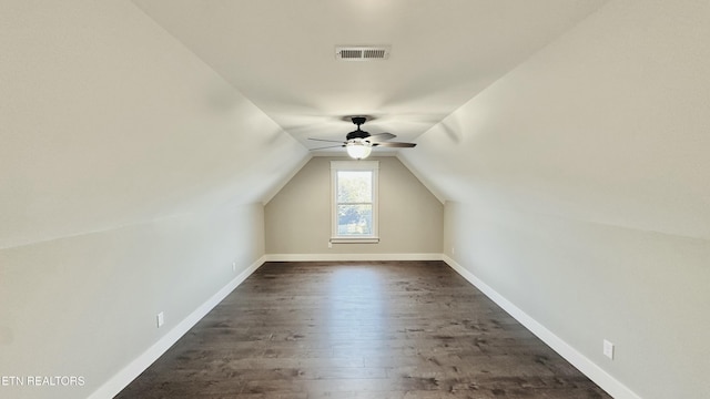 additional living space featuring baseboards, visible vents, lofted ceiling, ceiling fan, and dark wood-type flooring