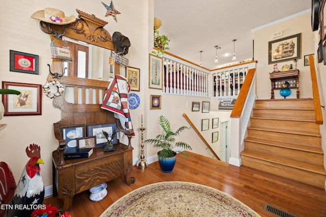 stairway featuring wood-type flooring and ornamental molding