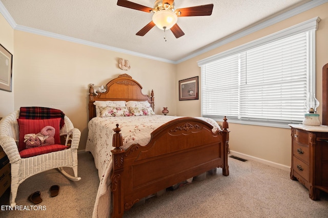 carpeted bedroom with a textured ceiling, ceiling fan, and crown molding