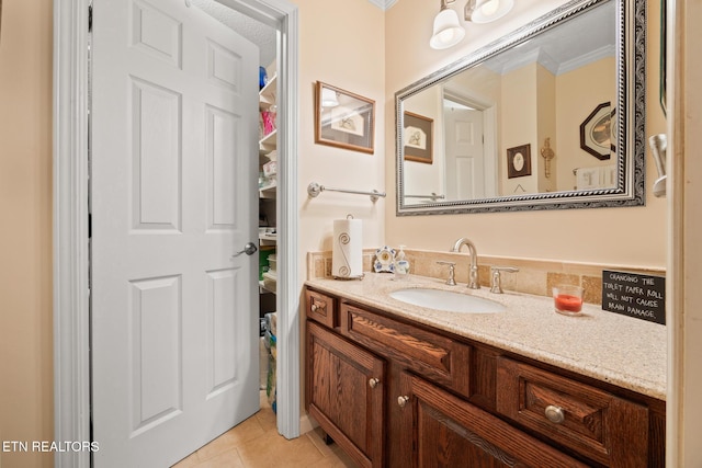 bathroom featuring vanity, tile patterned floors, and crown molding