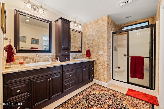 bathroom with crown molding, tile patterned flooring, vanity, and walk in shower