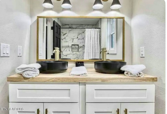 full bathroom featuring double vanity, a sink, and a shower with curtain