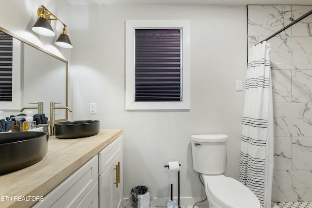 full bathroom featuring a stall shower, vanity, and toilet