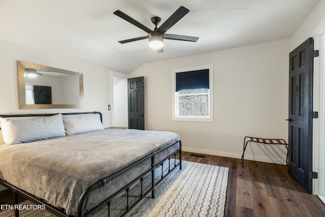 bedroom with dark wood-style floors, baseboards, vaulted ceiling, and a ceiling fan