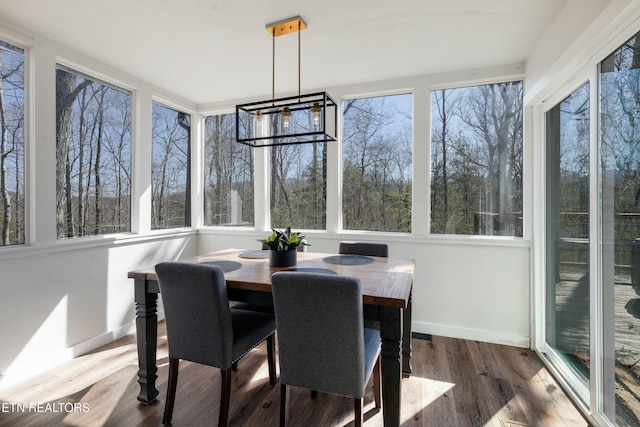 sunroom featuring a healthy amount of sunlight and an inviting chandelier