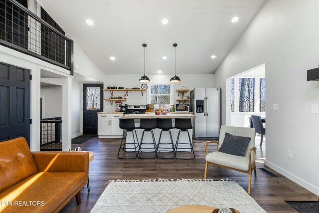 kitchen featuring open shelves, stainless steel appliances, light countertops, hanging light fixtures, and white cabinetry