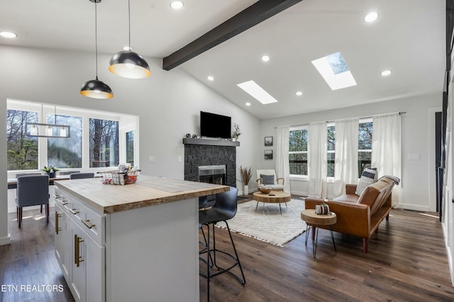 kitchen with pendant lighting, light countertops, open floor plan, and white cabinets