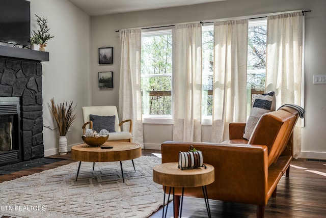 living area featuring dark wood-style floors, a fireplace, and baseboards