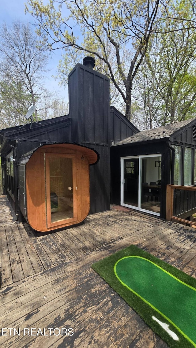 back of house with a wooden deck and a chimney