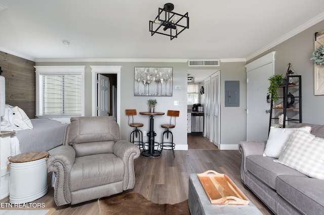 living room featuring dark hardwood / wood-style flooring, crown molding, electric panel, and a chandelier