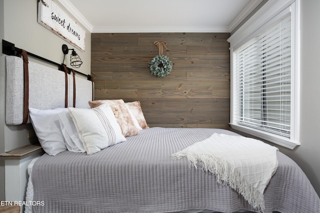 bedroom featuring wooden walls and crown molding