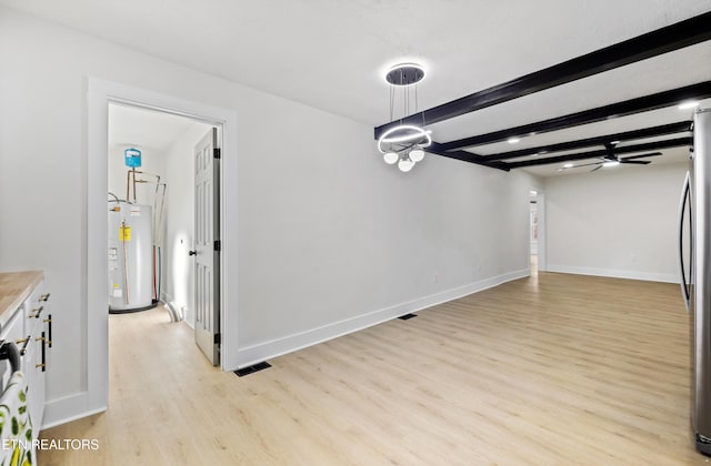 unfurnished dining area with beamed ceiling, light hardwood / wood-style floors, ceiling fan, and water heater