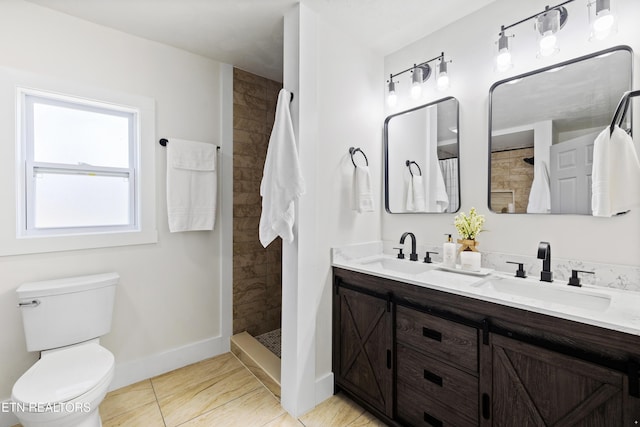 bathroom with tiled shower, vanity, toilet, and tile patterned flooring