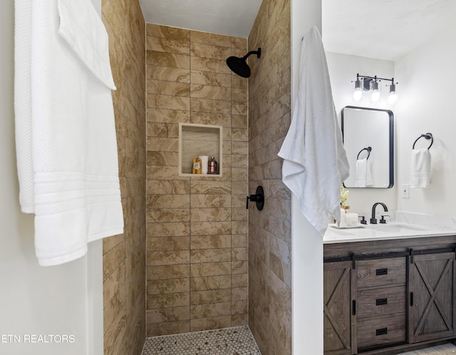 bathroom with vanity and a tile shower