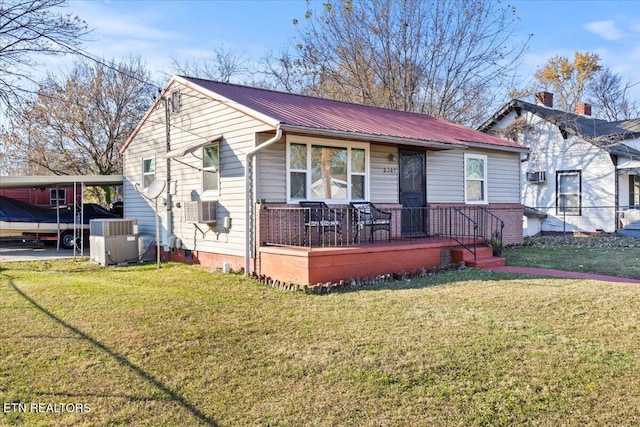 view of front of home featuring a carport, central air condition unit, and a front yard