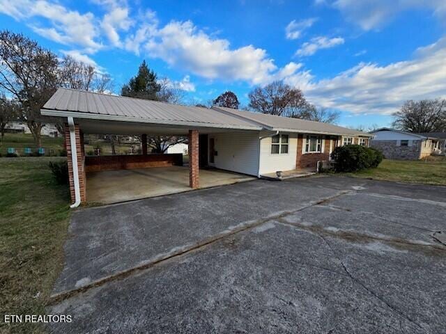 view of vehicle parking with driveway and a carport