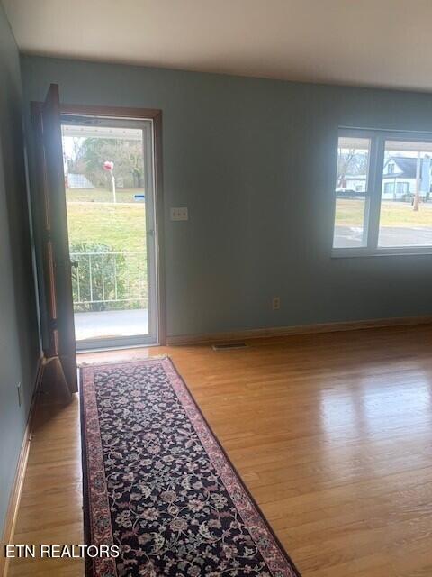 doorway to outside featuring light wood finished floors, visible vents, and baseboards