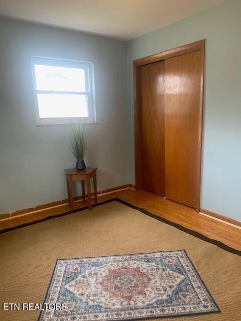 unfurnished bedroom featuring baseboards, a closet, and wood finished floors