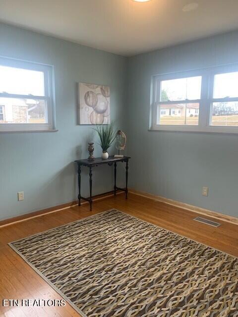 office featuring visible vents, baseboards, and wood finished floors