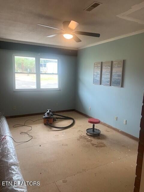 spare room with baseboards, a ceiling fan, visible vents, and crown molding