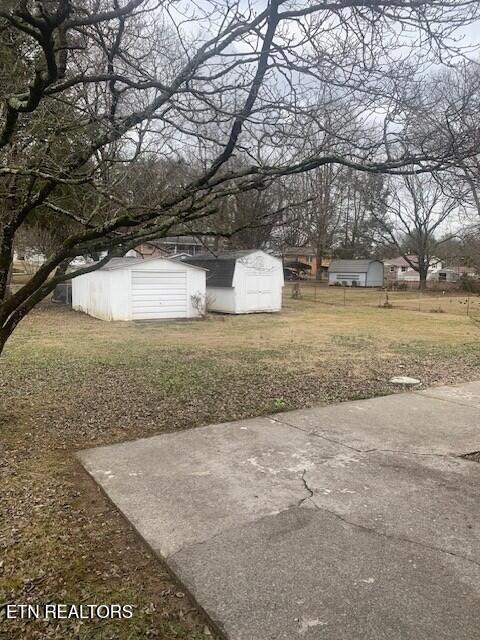 view of yard with a shed, fence, and an outbuilding