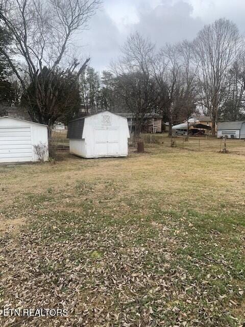 view of yard with a storage shed, fence, and an outdoor structure