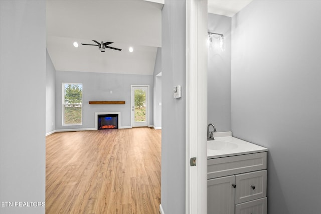 bathroom featuring a wealth of natural light, ceiling fan, wood-type flooring, and lofted ceiling