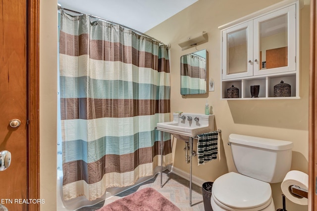 bathroom featuring tile patterned flooring, curtained shower, and toilet