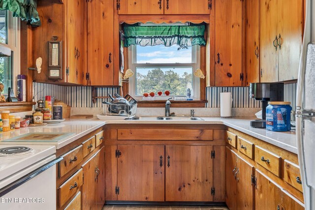 kitchen featuring stainless steel refrigerator, decorative backsplash, and sink