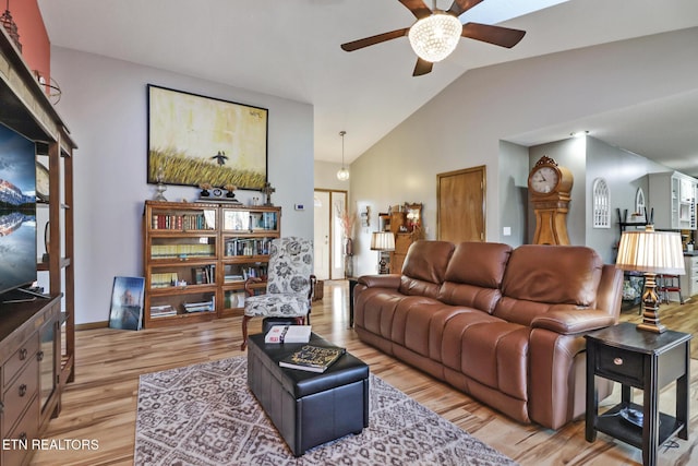 living room featuring ceiling fan, lofted ceiling, and light hardwood / wood-style flooring