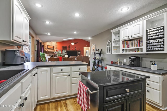 kitchen featuring white cabinets, a textured ceiling, light hardwood / wood-style flooring, and ceiling fan