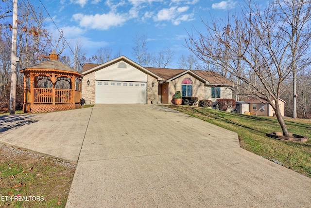 ranch-style home featuring a gazebo, a garage, and a front lawn